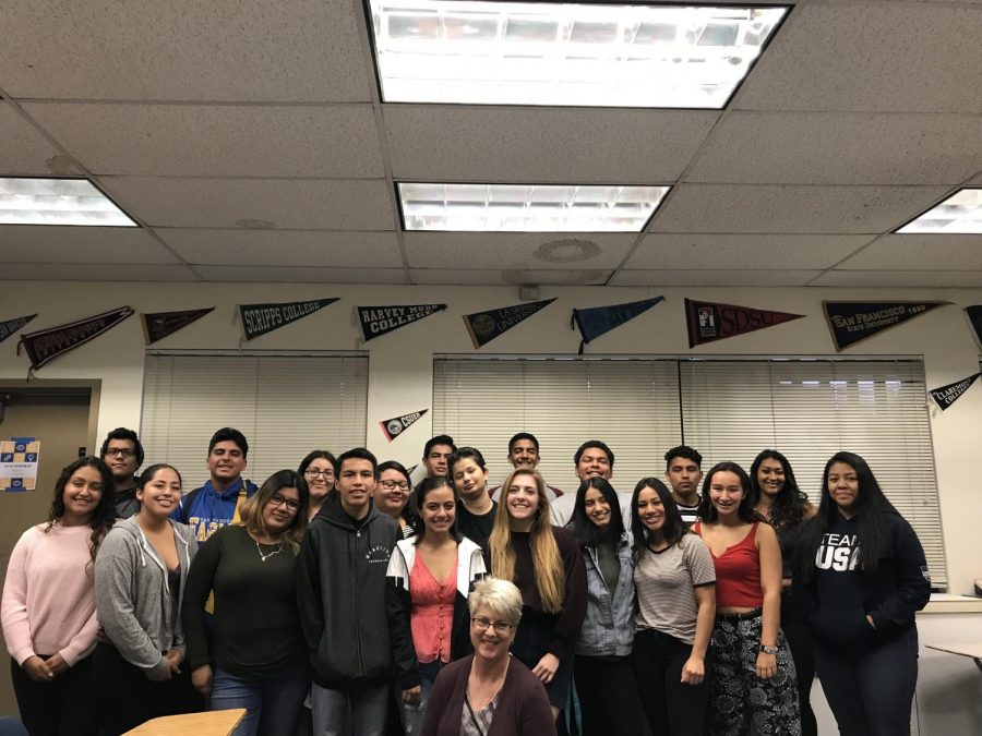 Students and teacher of the AVID class come together for a smiling photo.